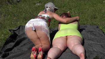 Mature lesbian with a strapon fucks a fat bisexual girlfriend outdoors in a public park. Two big asses in nature. PAWG. Amateur fetish. Milfs.