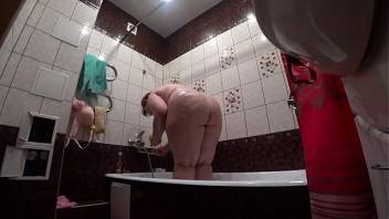Behind the scenes, a hidden camera is spying on a fat porn model with a big ass in the bathroom.
